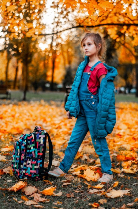 dziewczynka stojąca obok plecaka